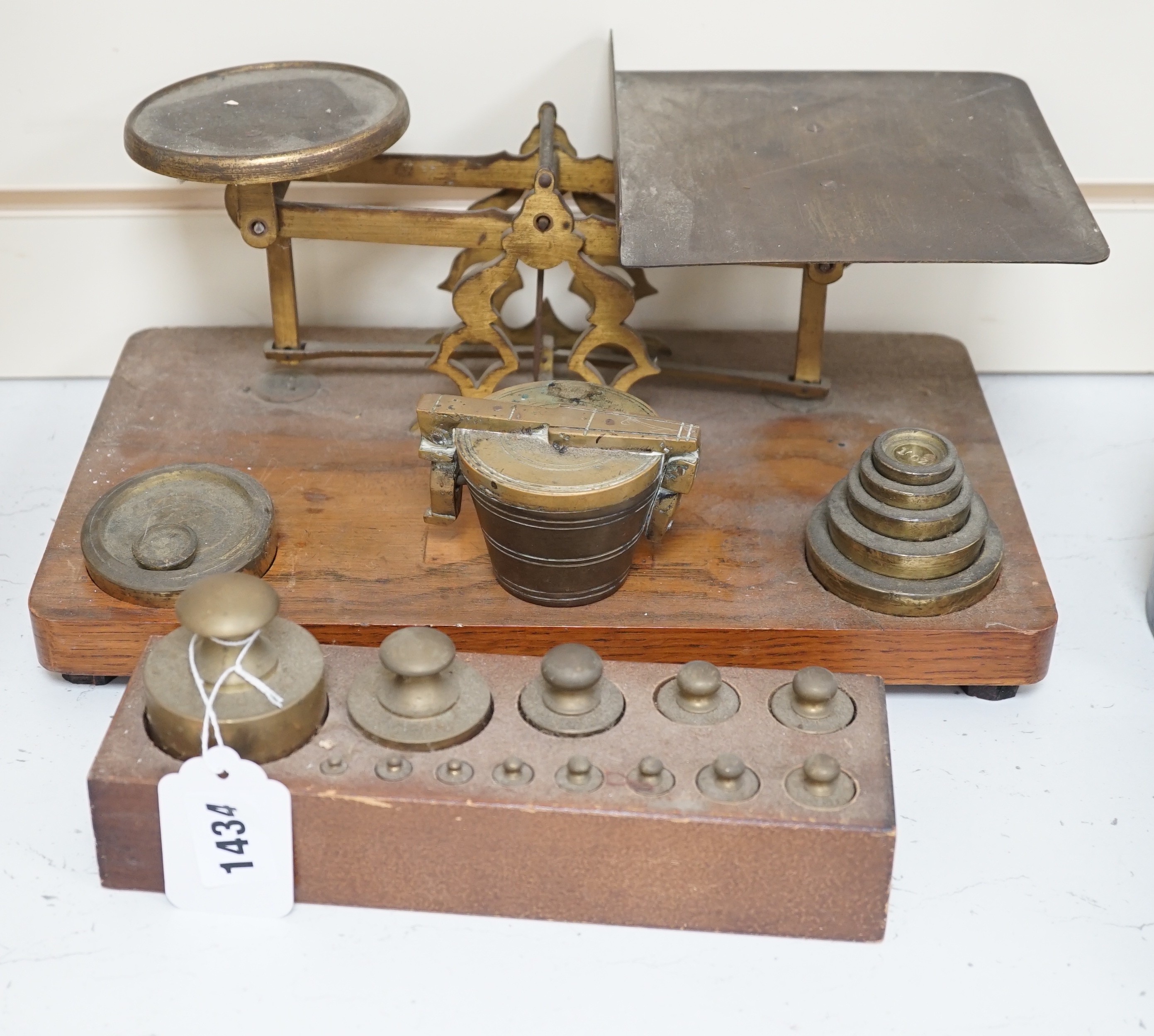 A set of brass postal scales and weights, a separate set of weights and another, set in wooden stand